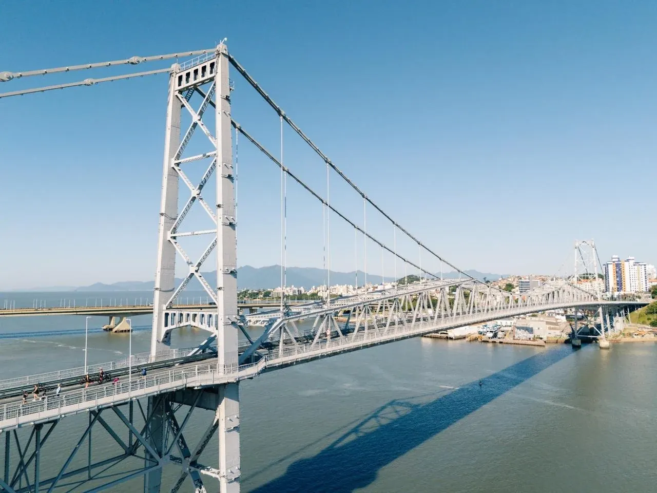 Ponte Hercílio Luz vista de perto, com o Centro de Florianópolis ao fundo